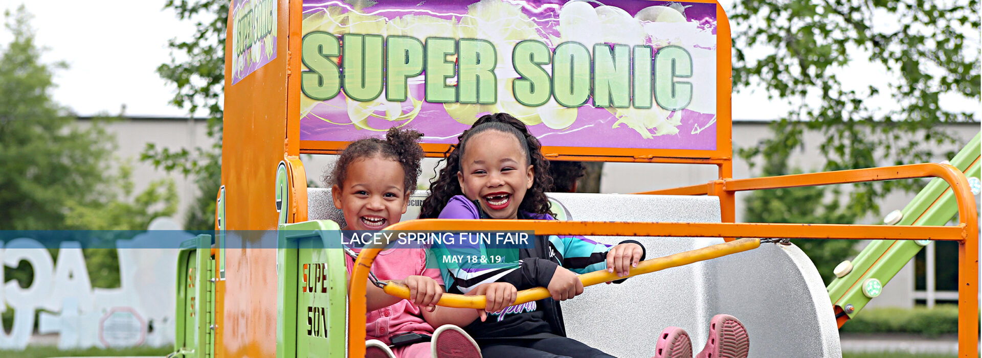 Two children enjoying a ride at the Lacey Fun Fair - click this image to learn more about the event